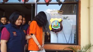seorang gadis yang menggunakan pakaian oren dibekuk oleh polisi